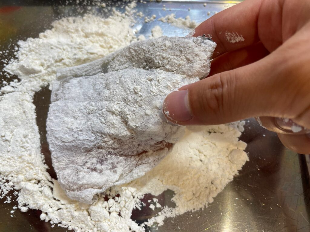 小麦粉をクロダイの切り身にまぶす