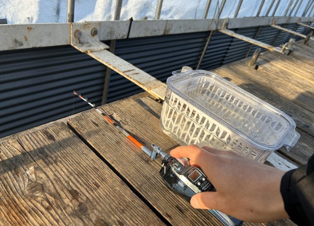 ワカサギ釣りの、電動リールで仕掛けを底まで落としている様子